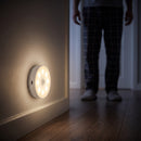 Luminária Aura acendendo sozinha e iluminando um corredor à noite