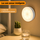 Luminária Aura acesa com luz branca quente fixada na parede